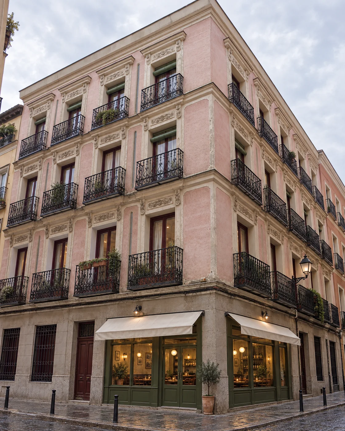 Concept illustration: a rose-plastered corner building with iron balconies and a bistro on the ground floor, Lavapiés, Madrid